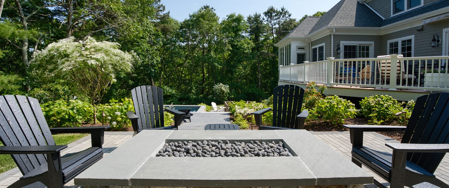 A cozy firepit area with chairs at a beautiful landscaping project built, designed, and maintained by CMS Landscape