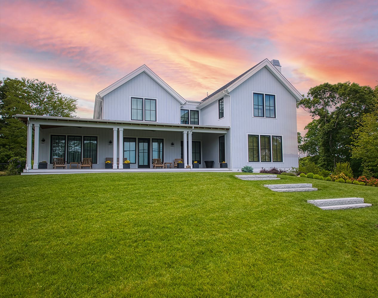 A stunning Cape Cod sunset lights up a beautiful landscaping project designed, built, and maintained by CMS Landscape