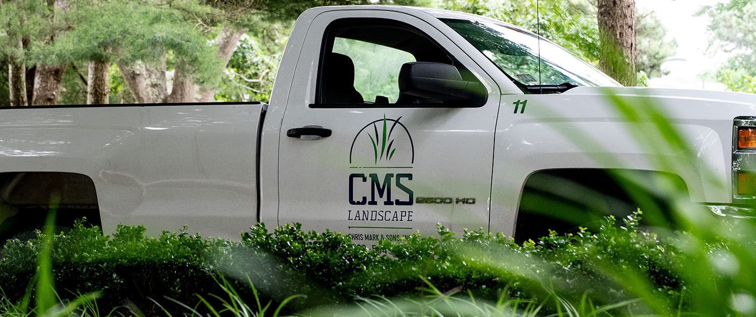 A CMS Landscape team truck sits at a landscaping project