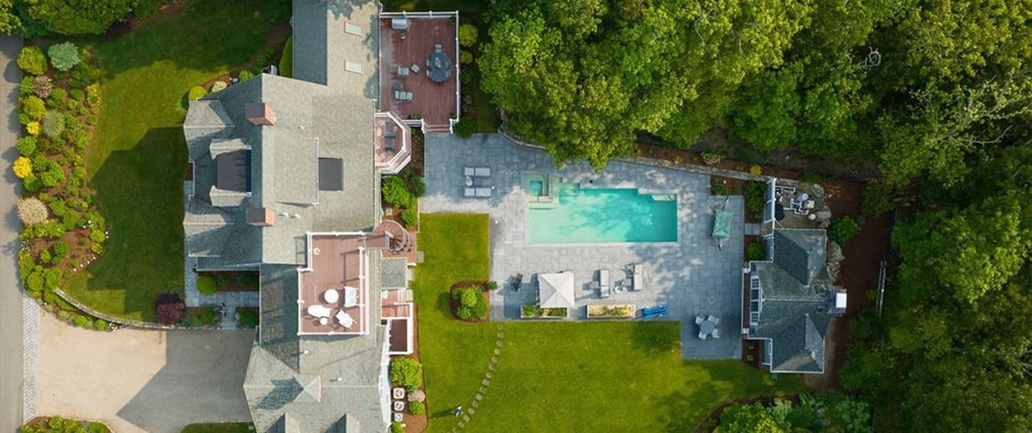 An aerial view of a home with a pool. This property is managed by CMS Landscape