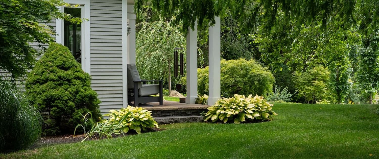A gorgeous lawn and flower bed, part of a property managed by CMS Landscape